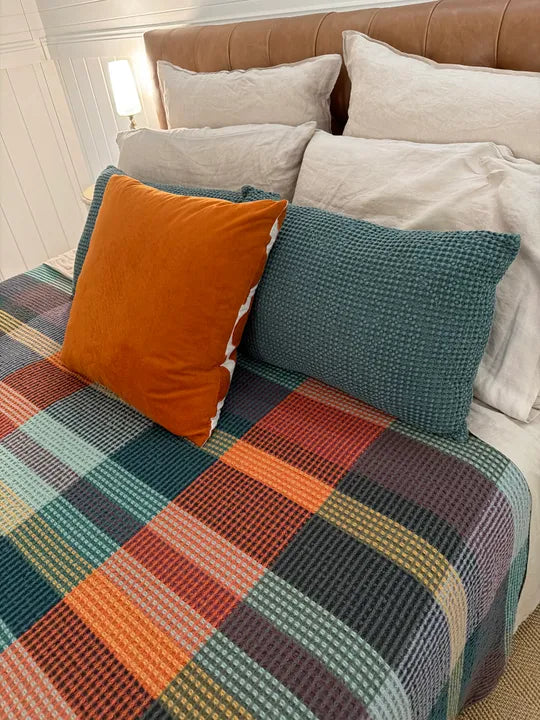 Vrou Vrou waffle cotton blanket in Cypress green tones, draped — Mopti Living
