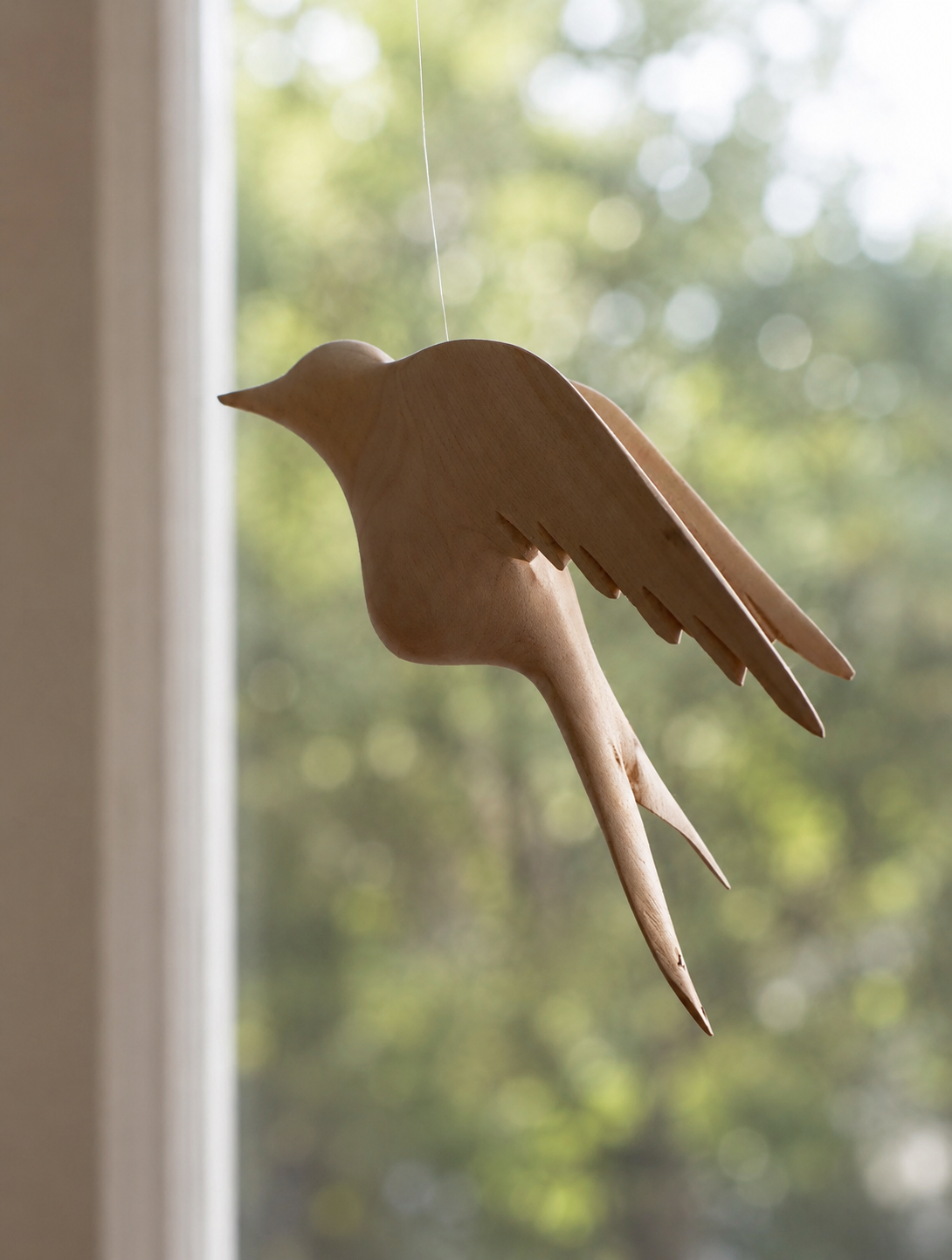 Hand-carved wooden sunbird sculpture suspended on wire with wings spread in flight — Mopti Living