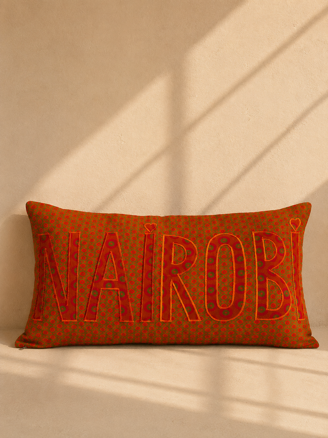 Nairobi shweshwe cushion cover in orange on green – hand-appliquéd lettering, handmade in Kenya | Mopti Living