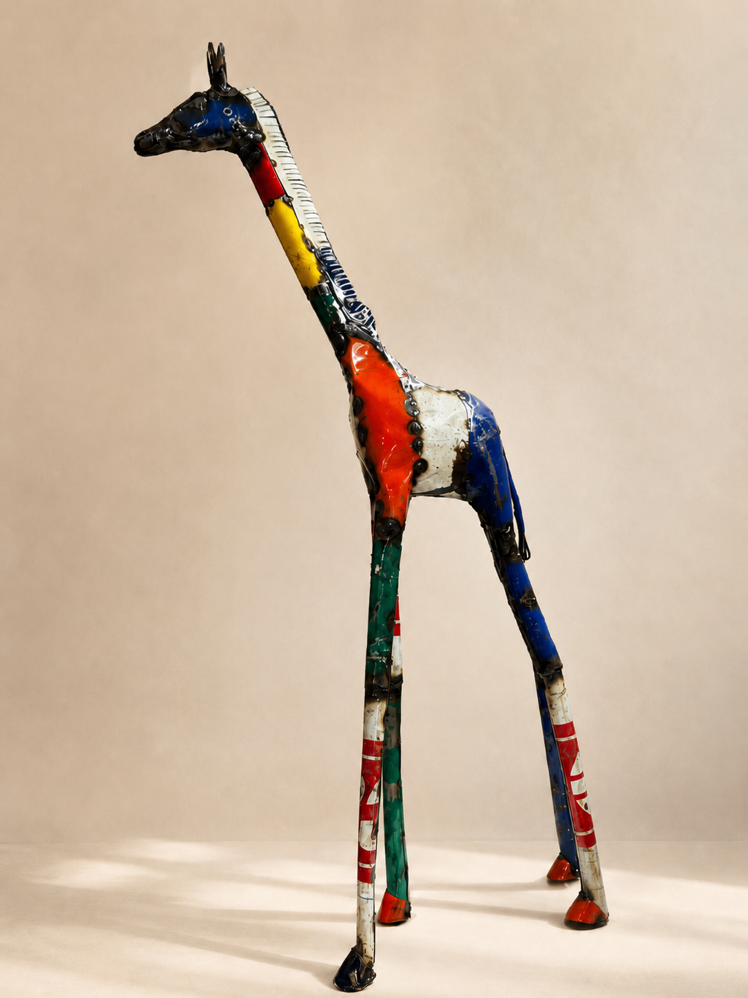 Handmade recycled metal giraffe sculpture, tall, with colourful joined panels in yellow, blue, red and green — Mopti Living