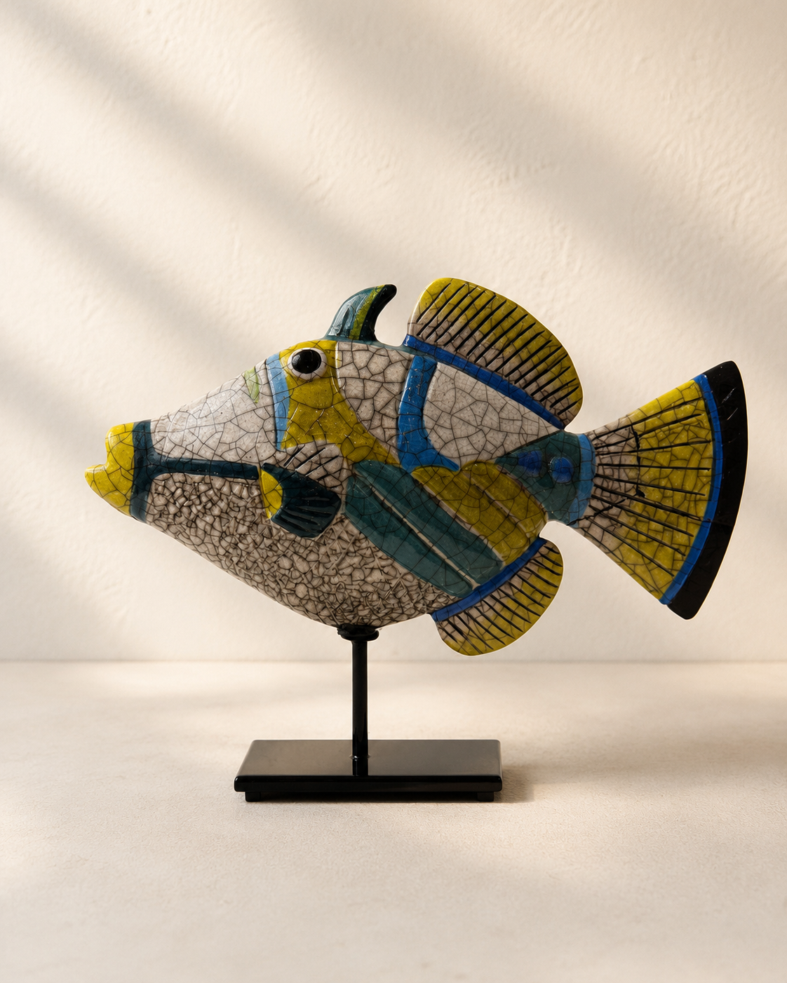 Hand-painted ceramic fish sculpture on a black stand, crackle glaze finish with blue, yellow and green details — Mopti Living