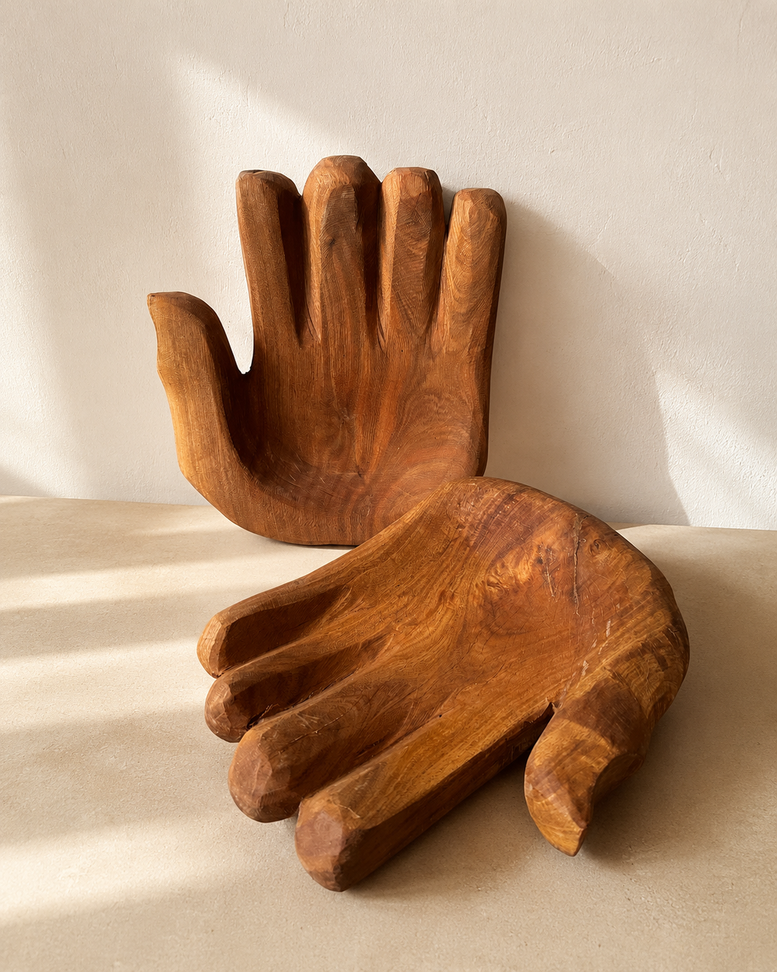 Hand-carved wooden closed hand sculpture with palm facing upward, showing natural wood grain and tool marks — Mopti Living