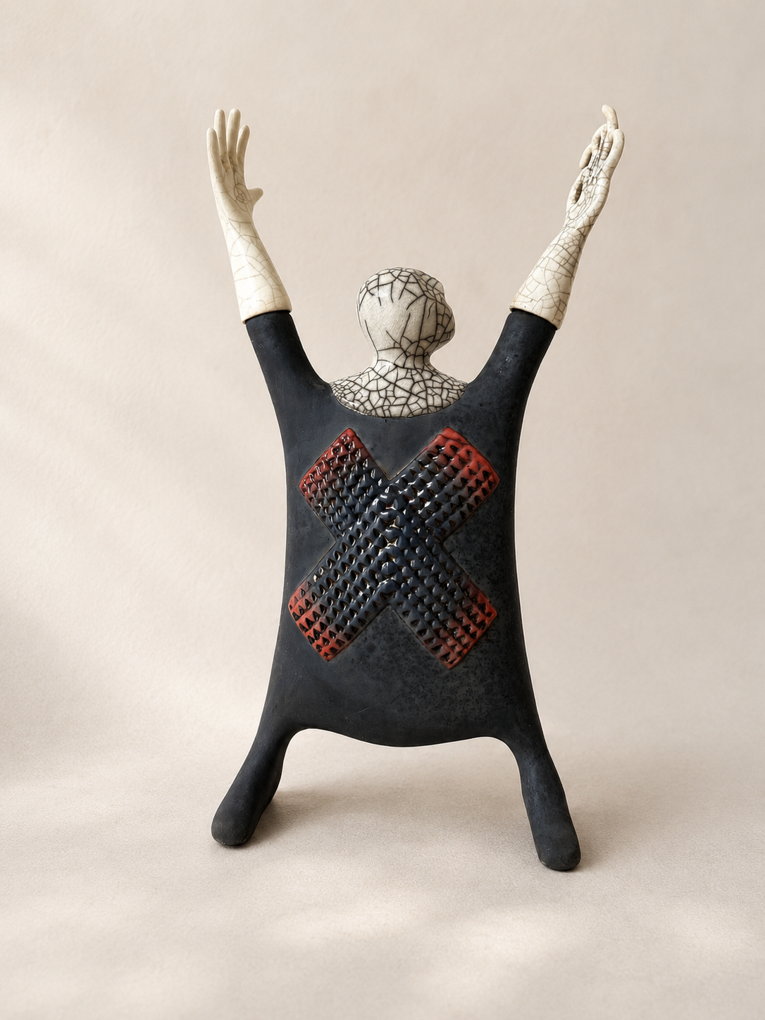 Raku-fired ceramic Man X sculpture with crackled surface and raised arms, inspired by Yoruba carving — Mopti Living