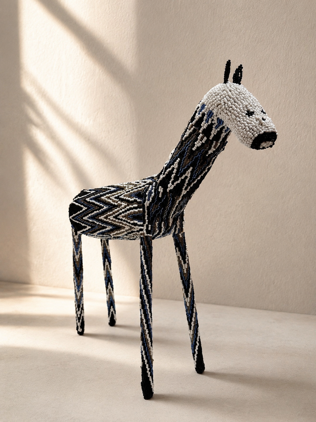 Hand-shaped beaded giraffe sculpture with black, white and blue beadwork pattern — Mopti Living