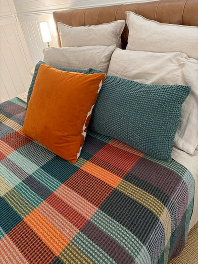 Vrou Vrou waffle cotton blanket in Cypress green tones, draped — Mopti Living
