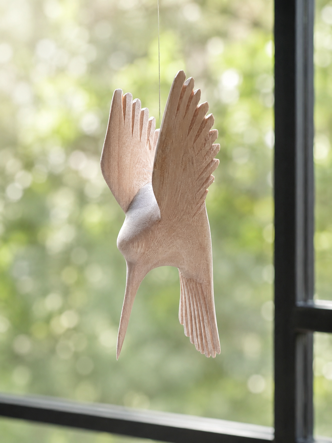 Hand-carved wooden sunbird sculpture suspended on wire with wings spread in flight — Mopti Living