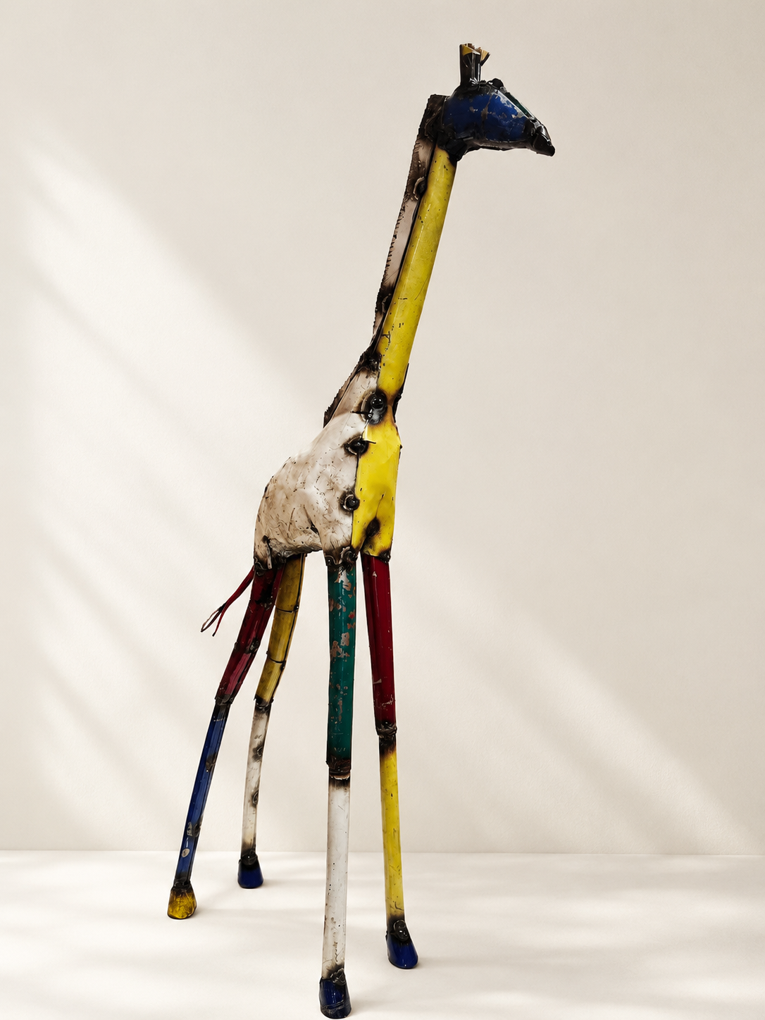 Handmade recycled metal giraffe sculpture, medium, with colourful joined panels in yellow, blue, red and green — Mopti Living