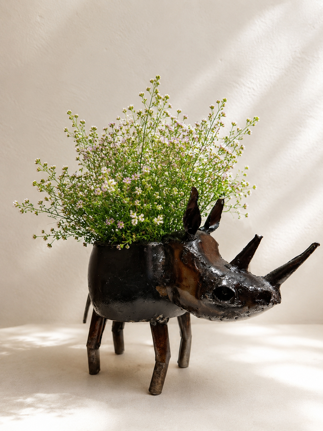 Handmade recycled metal rhino planter with dark finish and visible joins — Mopti Living
