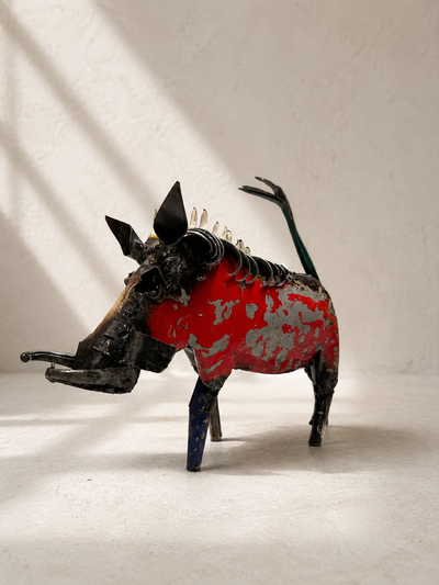 Handmade recycled metal warthog sculpture with colourful layered panels in red, blue, yellow and green — Mopti Living
